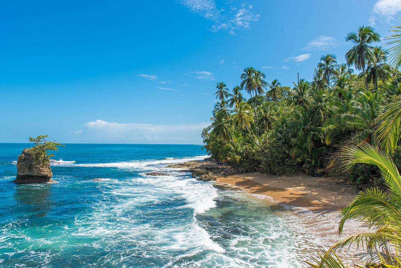 Wild waves hitting the shore of Manzanillo beach on a beautiful sunny day, near Puerto Limon, Costa Rica