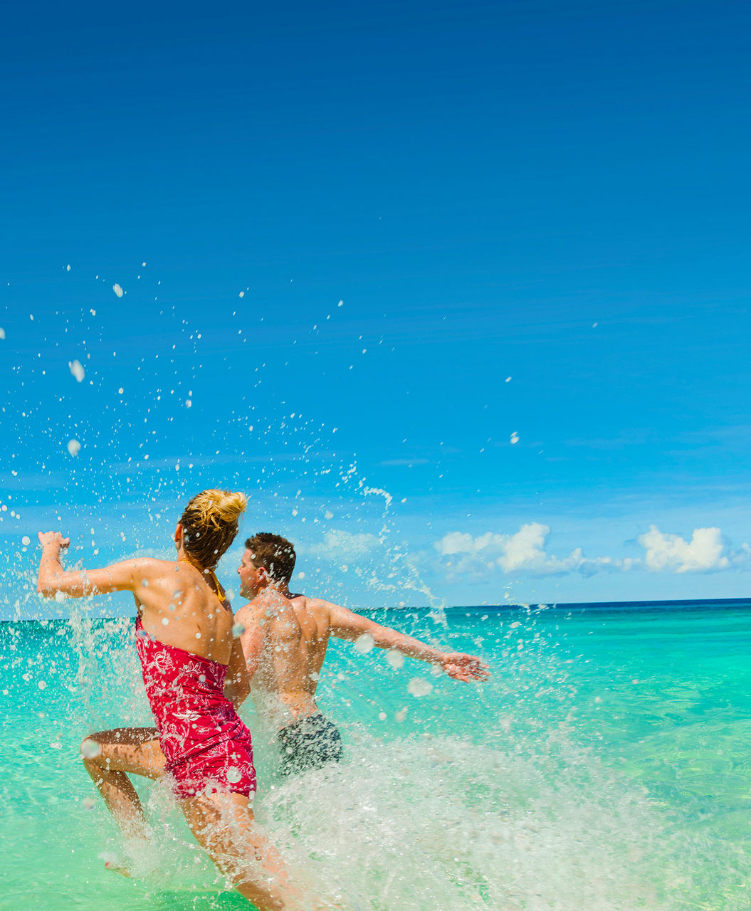 Couple Splashing at the beach, George Town, Grand Cayman | HP Mobile